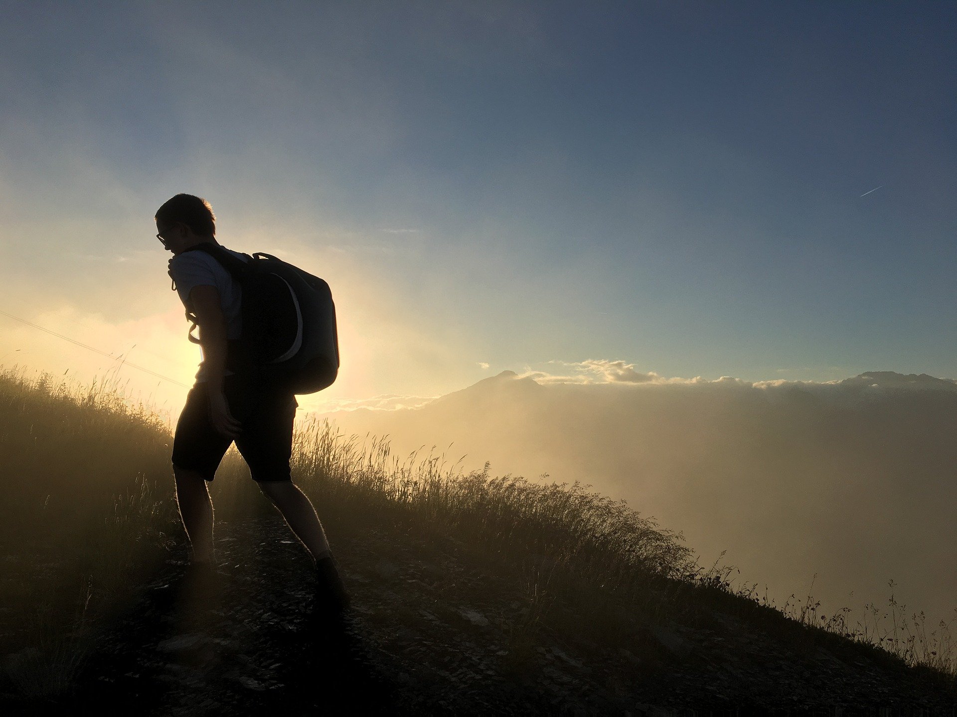 Nur Mut! Silhouette eines Wanderers, der Bergauf geht